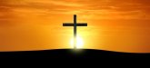 Symbolbild Kirchen; Kirchenkreuz mit einem Sonnenuntergang im Hintergund