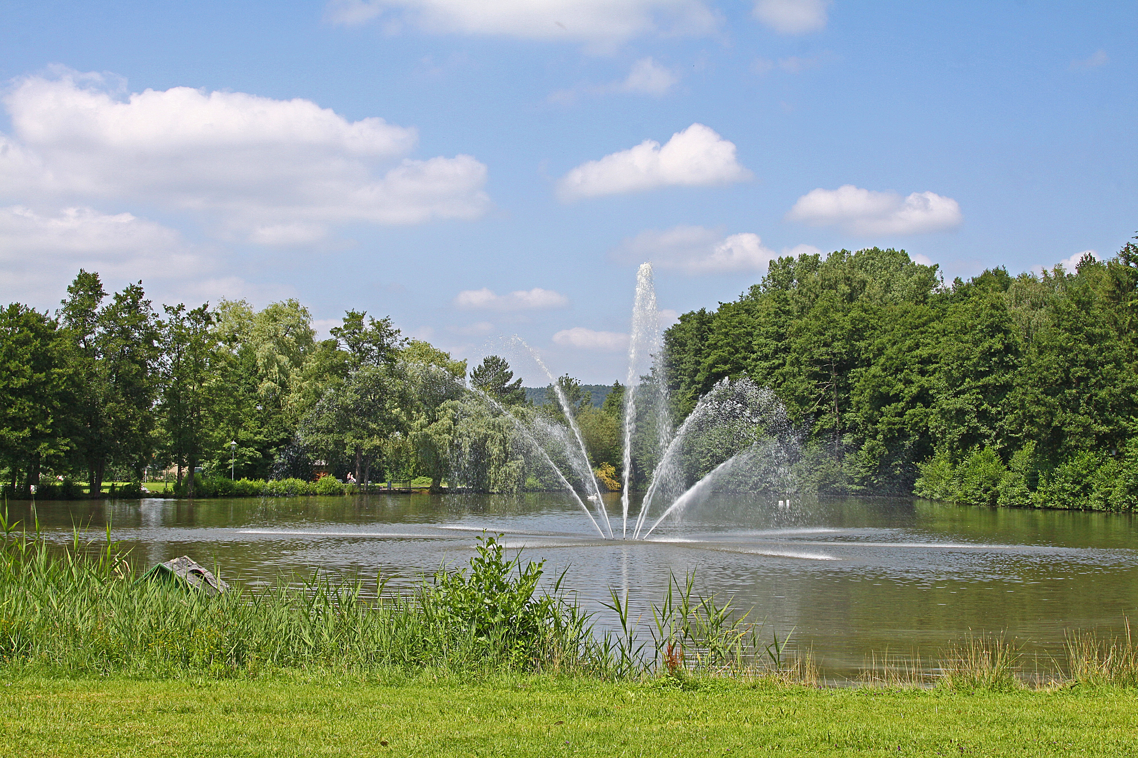 Blick auf die Wasserfontäne am kleinen See im Kurpark Bad König