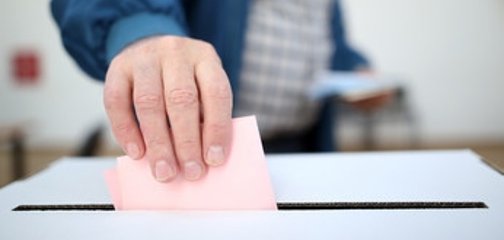 Symbolbild Wahlen; Wahlunterlagen werden in Wahlurne geworfen