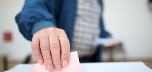 Symbolbild Wahlen; Wahlunterlagen werden in Wahlurne geworfen